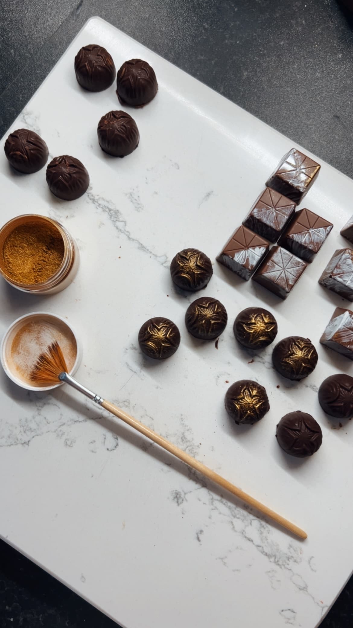 Bonbons being gilded by hand with gold dust